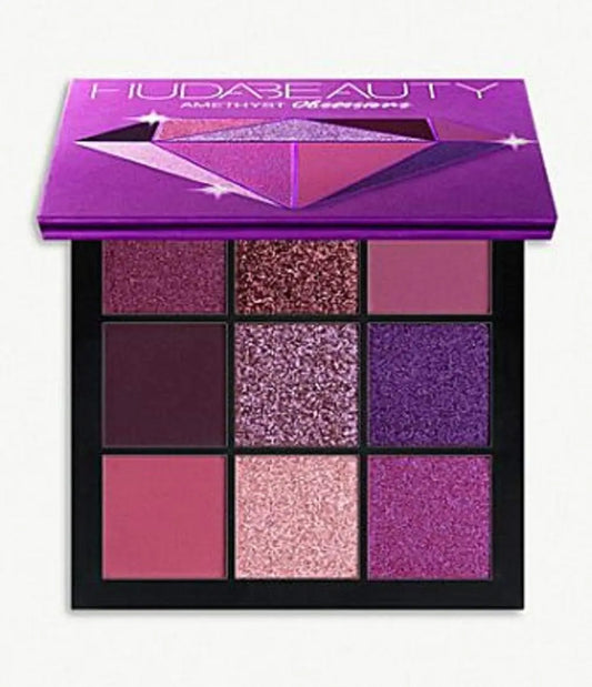 Huda Beauty eyeshadow palette with purple and pink shades on a white background