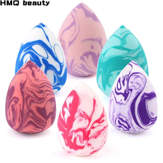 Set of colorful marbled makeup sponges on a white background with 'HMQ beauty' branding.