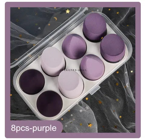 Set of purple makeup sponges in a clear plastic case on a starry background.