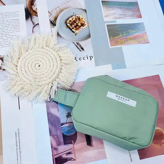 Green makeup bag with a label on a magazine background