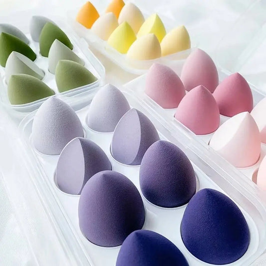 Set of colorful makeup sponges in a clear plastic case on a white background