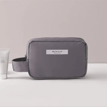 Gray makeup bag with 'MAKEUP REVOLUTION' label on a light background