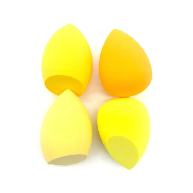 Four yellow makeup sponges on a white background