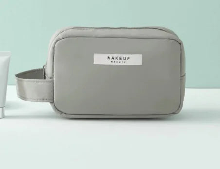 Gray makeup bag with 'MAKEUP' label on a light green background