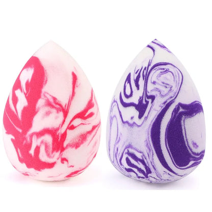 Two marbled eggs, one pink and white, one purple and white, on a white background.